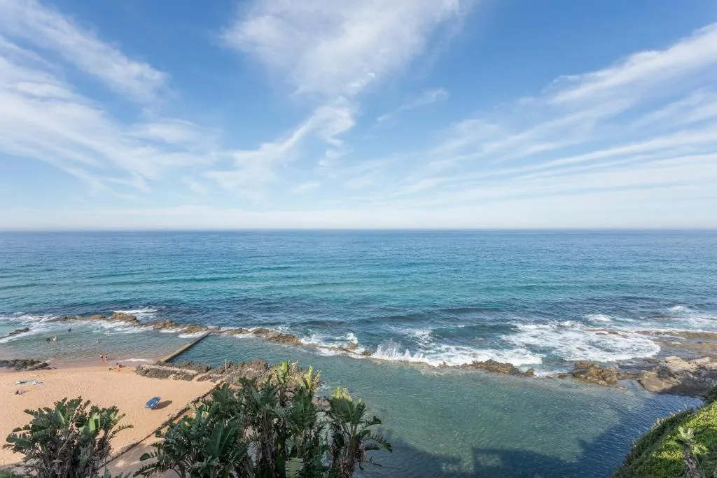 Wide daytime view over the rocky shoreline and tidal pool at Chaka's Cove