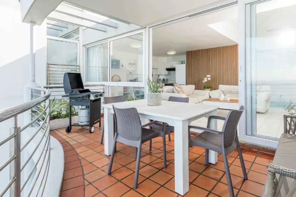 Balcony dining table opening onto the open plan living area with a sea view at Ocean Blue