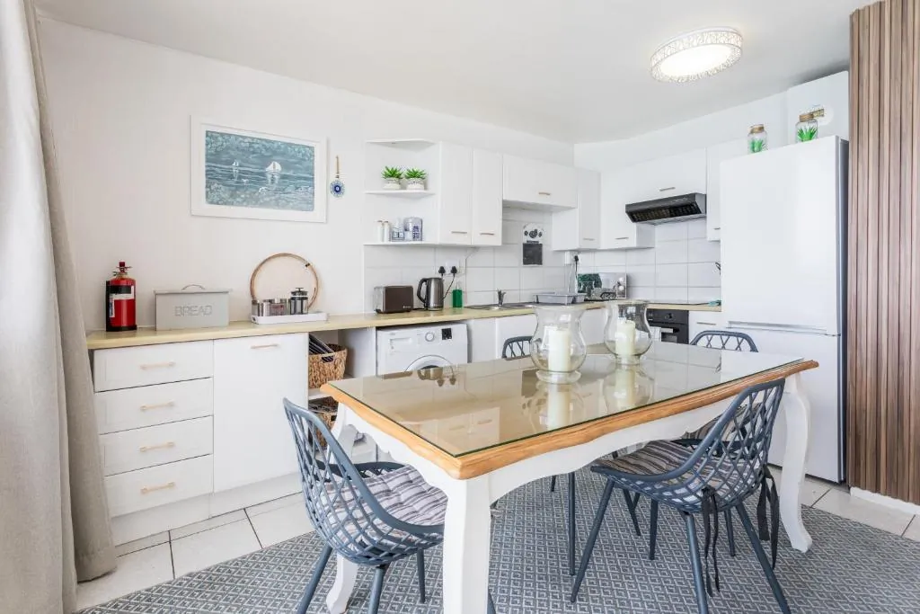 Kitchen with a wooden dining table and blue chairs at Ocean Blue