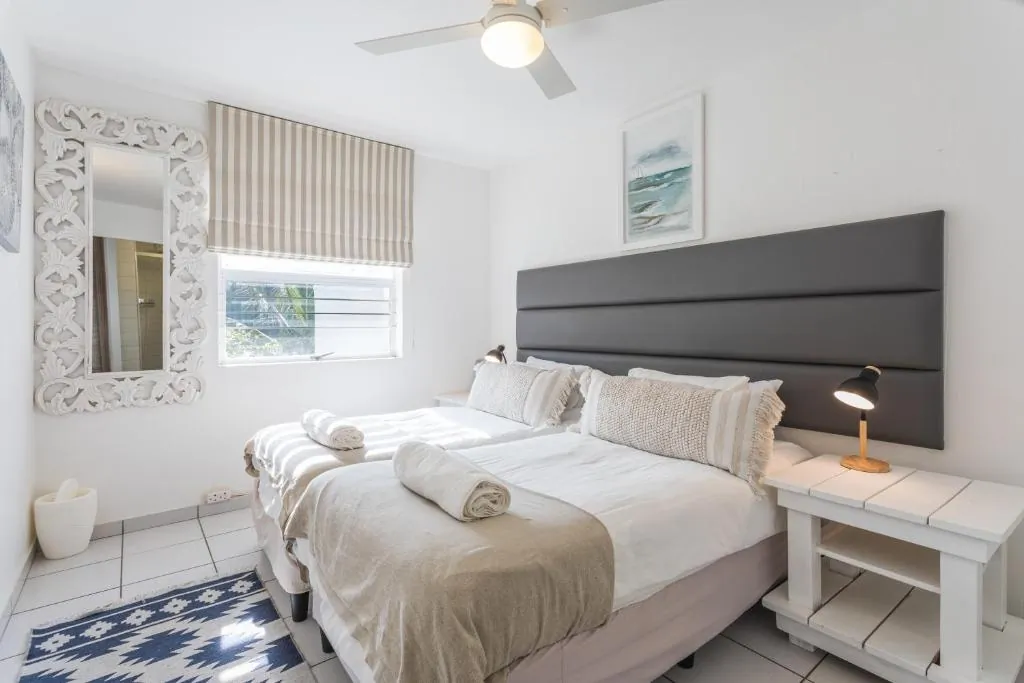 Second bedroom with a double bed and a large mirror at Ocean Blue