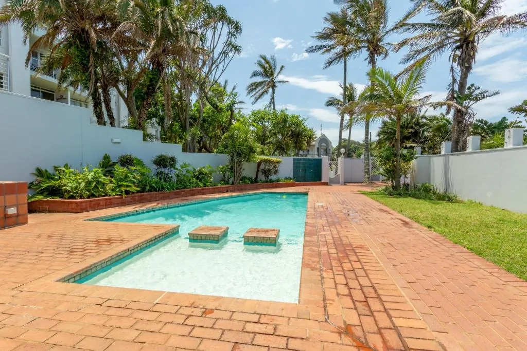 Pool on site with sun loungers on a brick deck at Chaka's Cove, Ballito