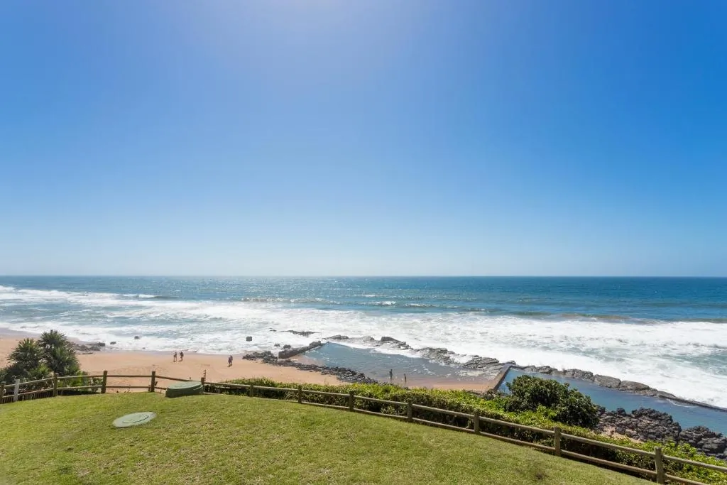 Sweeping view over the golden beach and blue ocean at Chaka's Cove