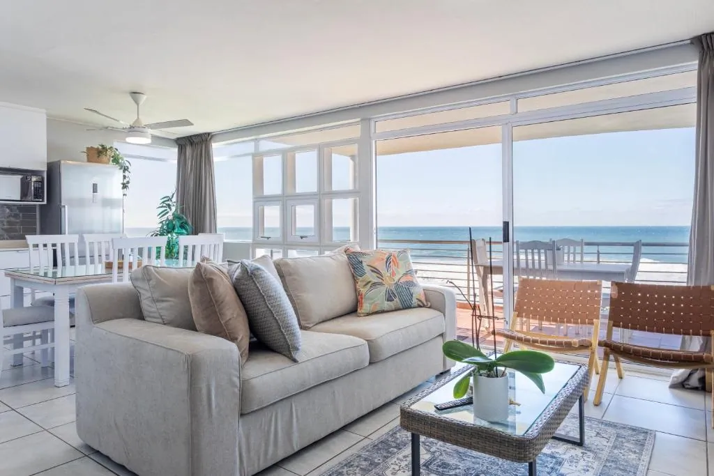 Living area with a grey sofa and sliding doors onto the sea view balcony at Ocean Pearl