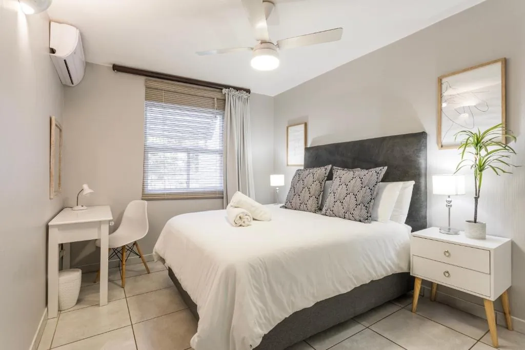 Main bedroom with a double bed, a desk and air conditioning at Ocean Pearl