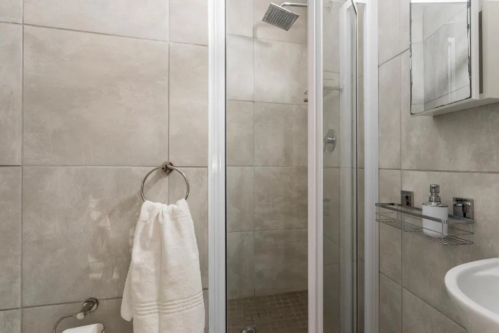 Second bathroom with a glass shower and a basin at Ocean Pearl