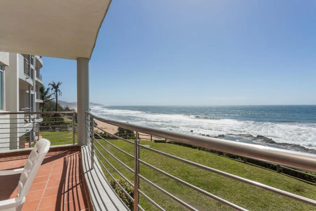 Balcony with a glass and steel railing looking along the Ballito coastline at Ocean Pearl